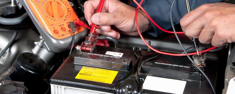 The mechanic is testing the voltage of a car battery, (speedalternators.com)