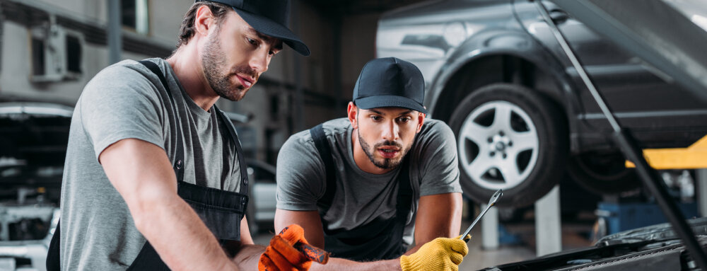 professional manual workers repairing car in mechanic shop, (speedalternators.com).