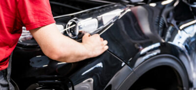 male car mechanic at autosalon hands on black car, (speedalternators.com).